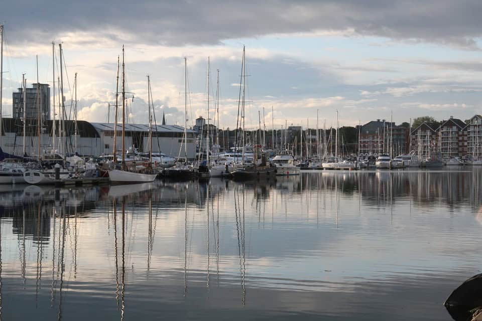 Elegant marina with sailboats and modern buildings in Suffolk, showcasing vibrant waterfront busines.