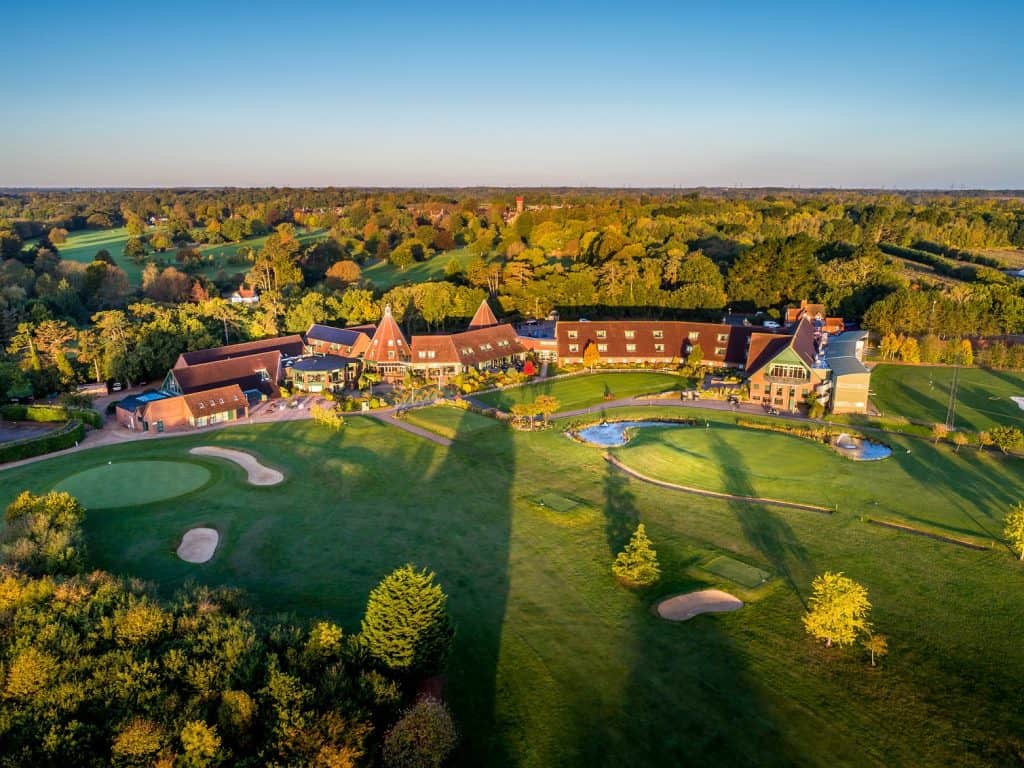 Aerial view of Suffolk golf course surrounded by lush countryside and trees.