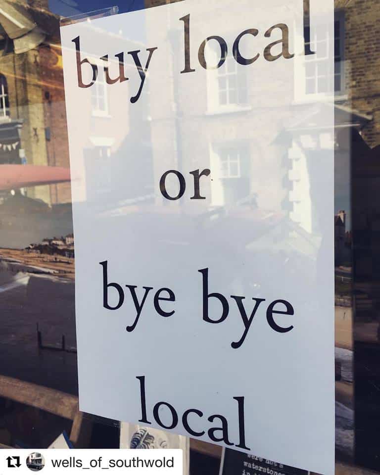 Support local businesses buy local message on shop window.