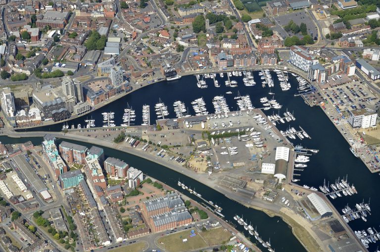 Suffolk waterfront with marina and historic buildings in an aerial view.