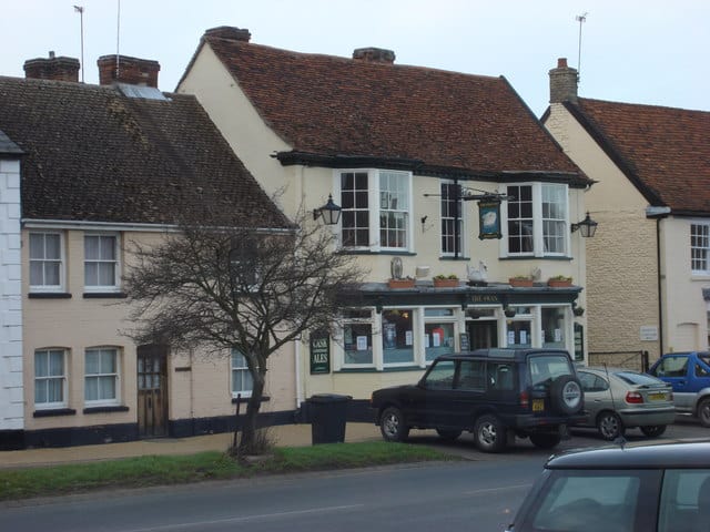 Traditional Suffolk pub with outdoor seating and parking in a village setting.