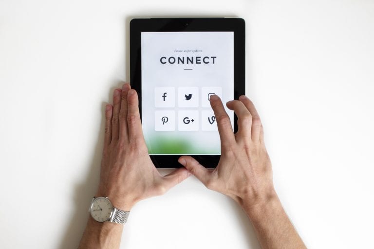 Person using a tablet to access social media platforms for business networking.
