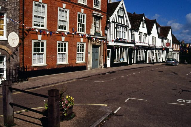 Traditional Suffolk townscape with Tudor-style architecture and vibrant street scene.