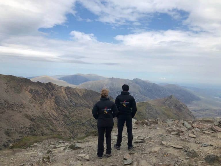 Hikers enjoying panoramic views from a mountain summit in Suffolk.