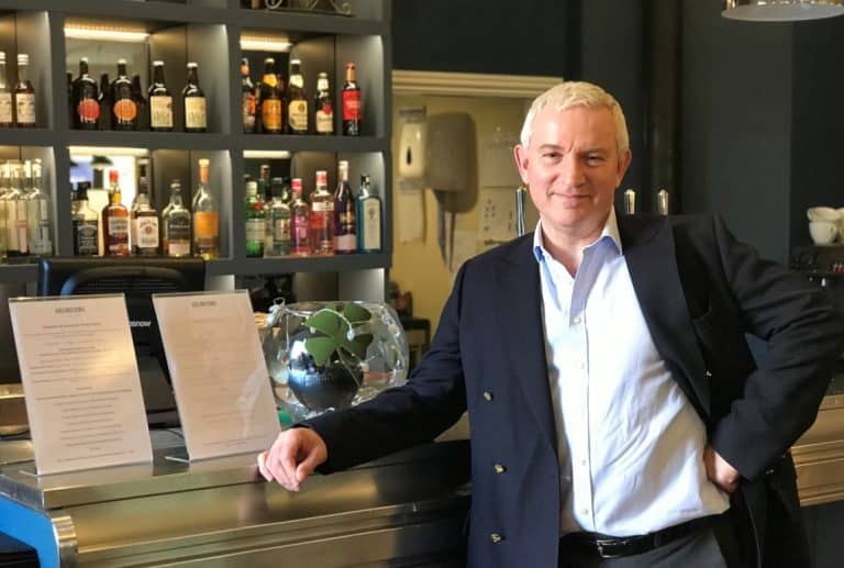 Businessman standing at a bar in a stylish pub or restaurant in Suffolk.
