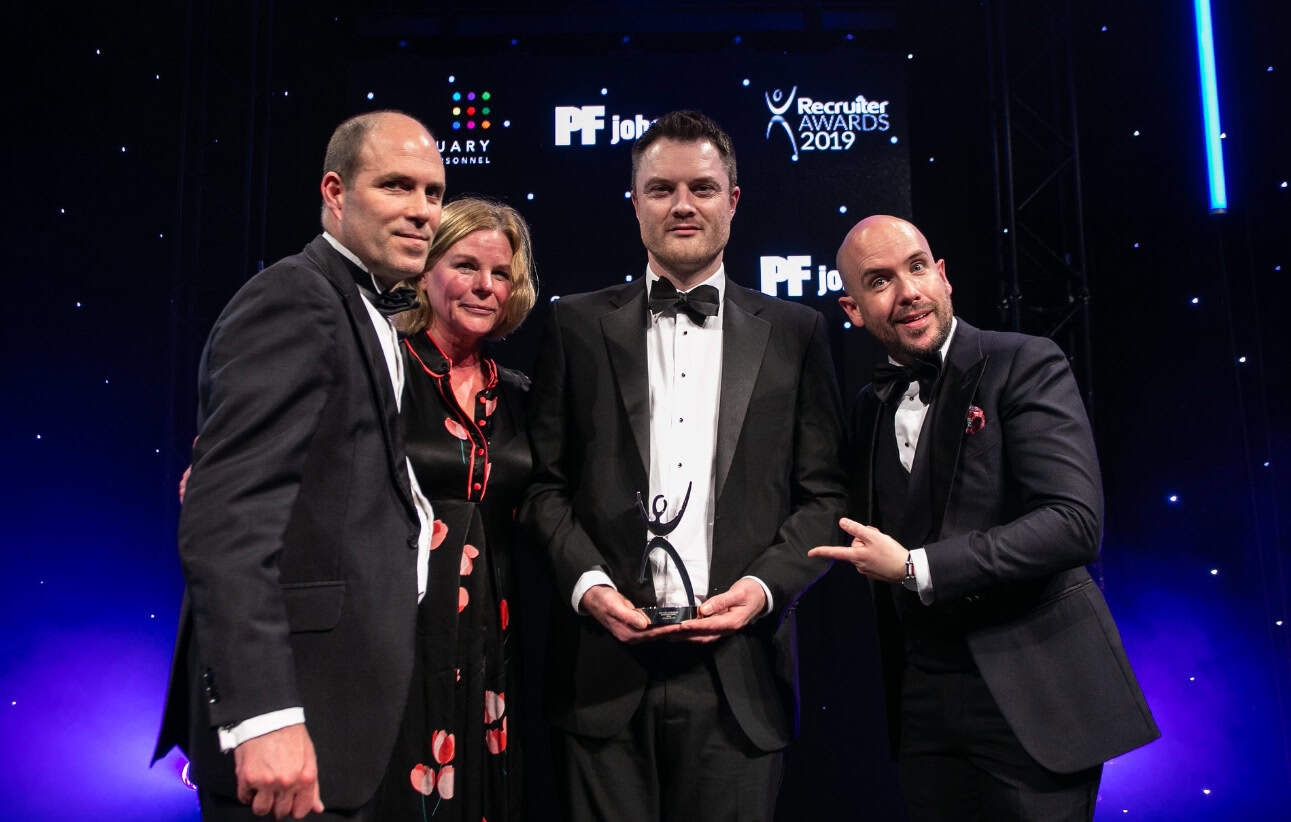 Group of four professionals at Suffolk Business Awards 2019, dressed in formal attire on stage.