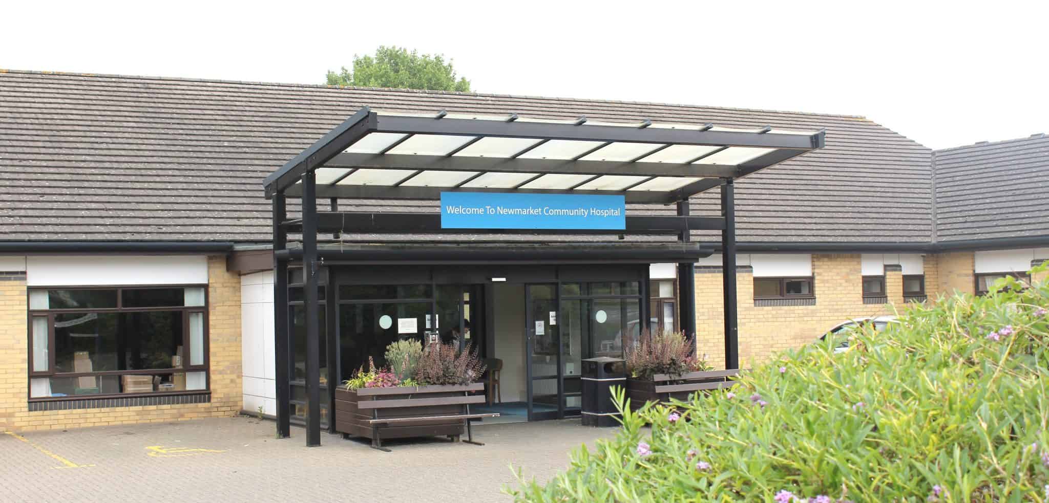 Suffolk Community Hospital entrance with welcoming signage and garden planters.