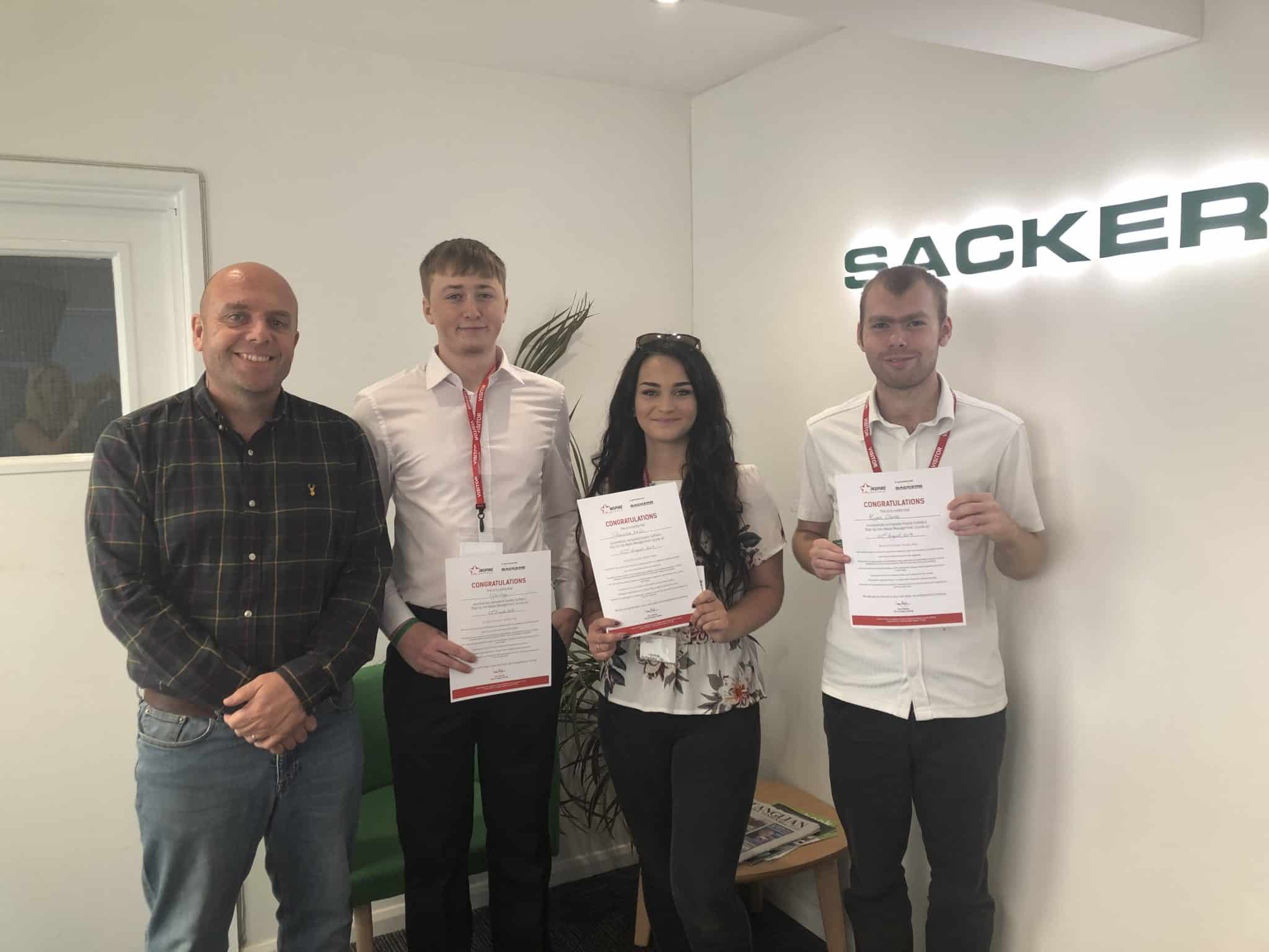 Group of young professionals holding certificates at Suffolk Business event.