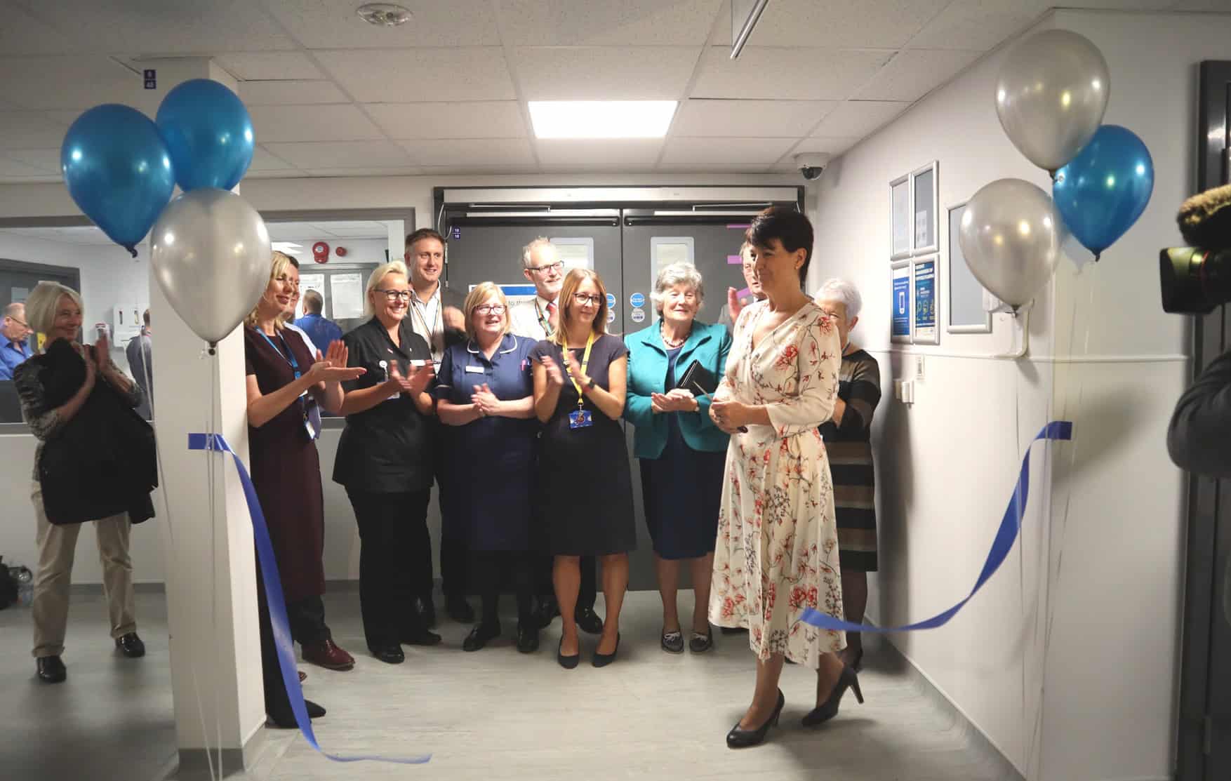 Business office opening event with staff and ribbon-cutting in Suffolk.