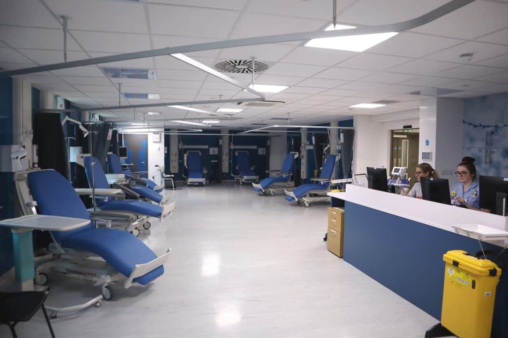 Well-equipped hospital blood donation room with multiple chairs and medical staff.