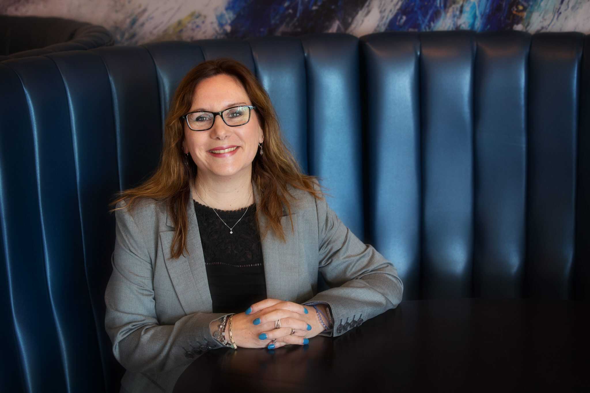 Businesswoman smiling at a meeting in Suffolk, showcasing professional success.
