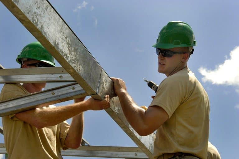 Construction workers assembling scaffolding on a building site in Suffolk.