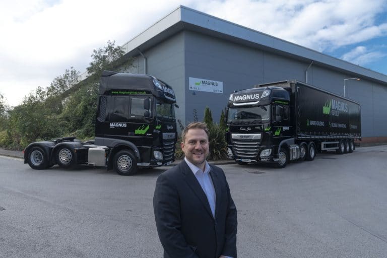 Suffolk Business logistics with Magnus trucks and a professional man outside warehouse.