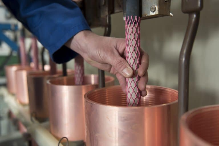 Copper pipe manufacturing, industrial production, metalworking, factory, manufacturing process.