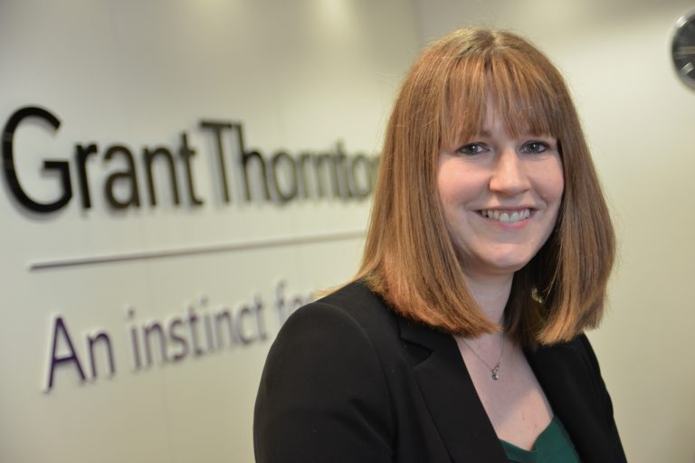 Suffolk business professional woman smiling in office setting.