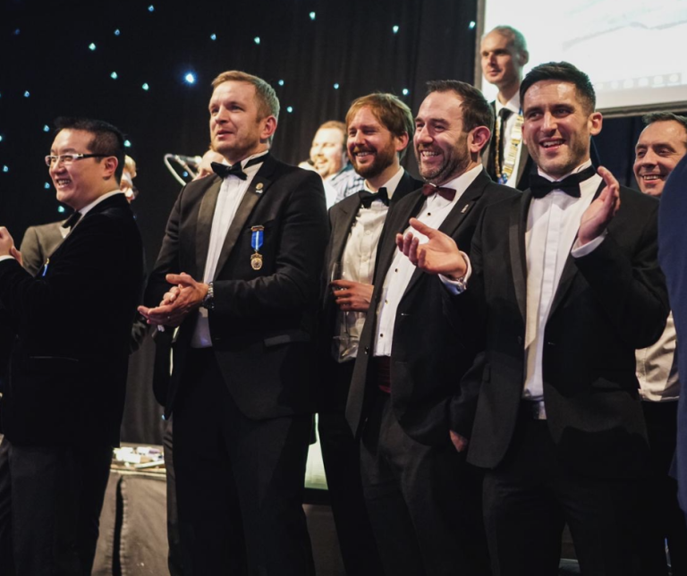 Business professionals in formal attire at Suffolk Business awards event.