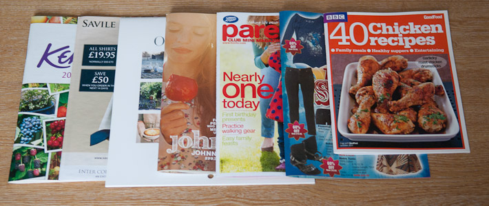 Collection of Suffolk Business magazines and cookbooks on a wooden table.
