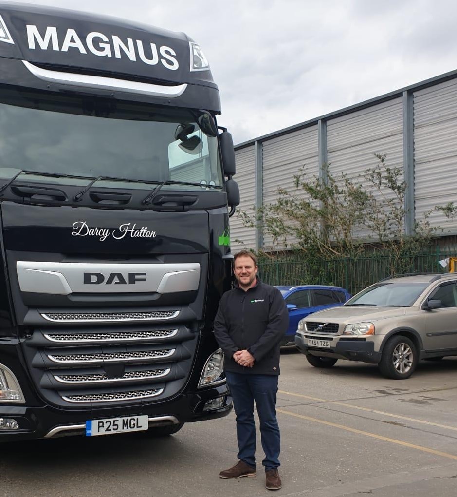 Professional truck driver standing beside a large DAF truck in Suffolk.