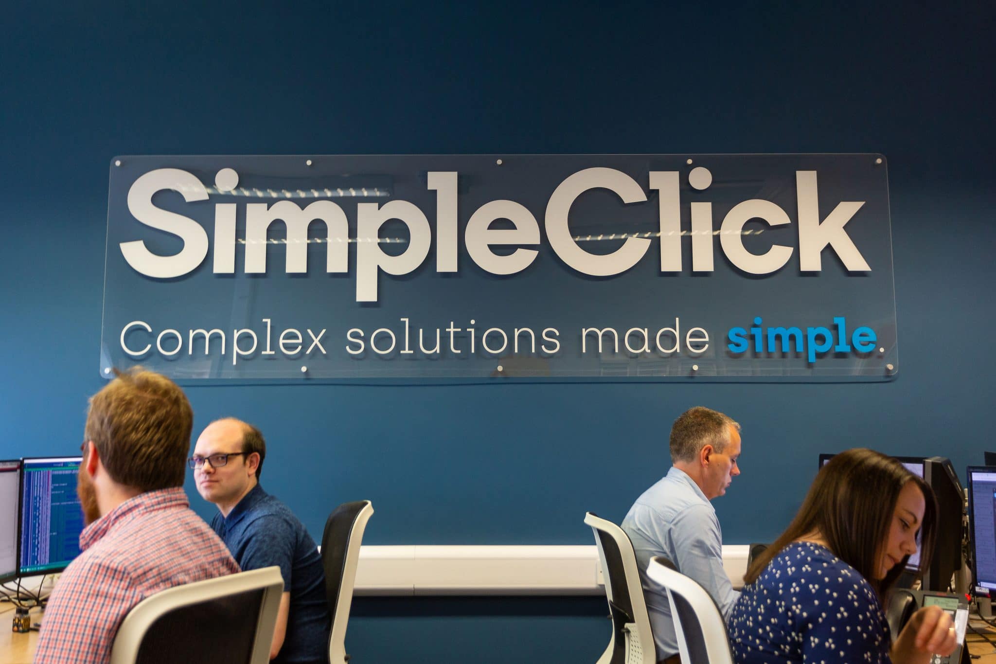 Business team working at computers in SimpleClick office, Suffolk.