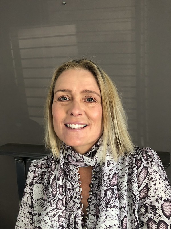 Businesswoman smiling in modern office setting, promoting professional services in Suffolk.