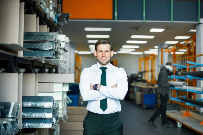 Business professional in warehouse with shelves and industrial equipment in Suffolk.