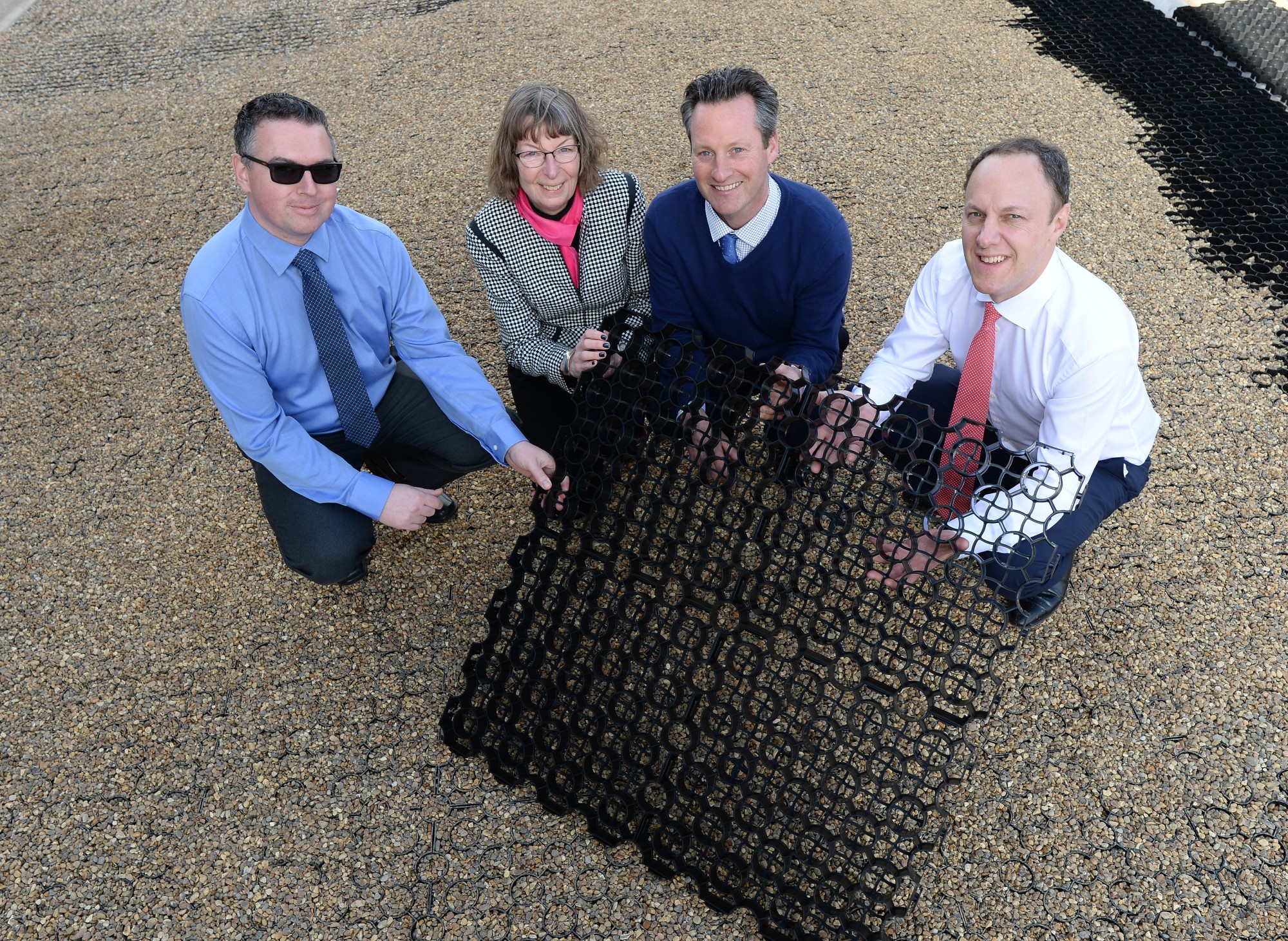 Suffolk Business team working together outdoors on a gravel surface.