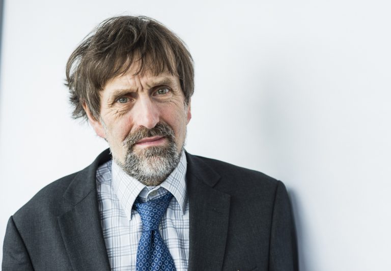 Businessman with a beard in a suit and tie, looking serious.