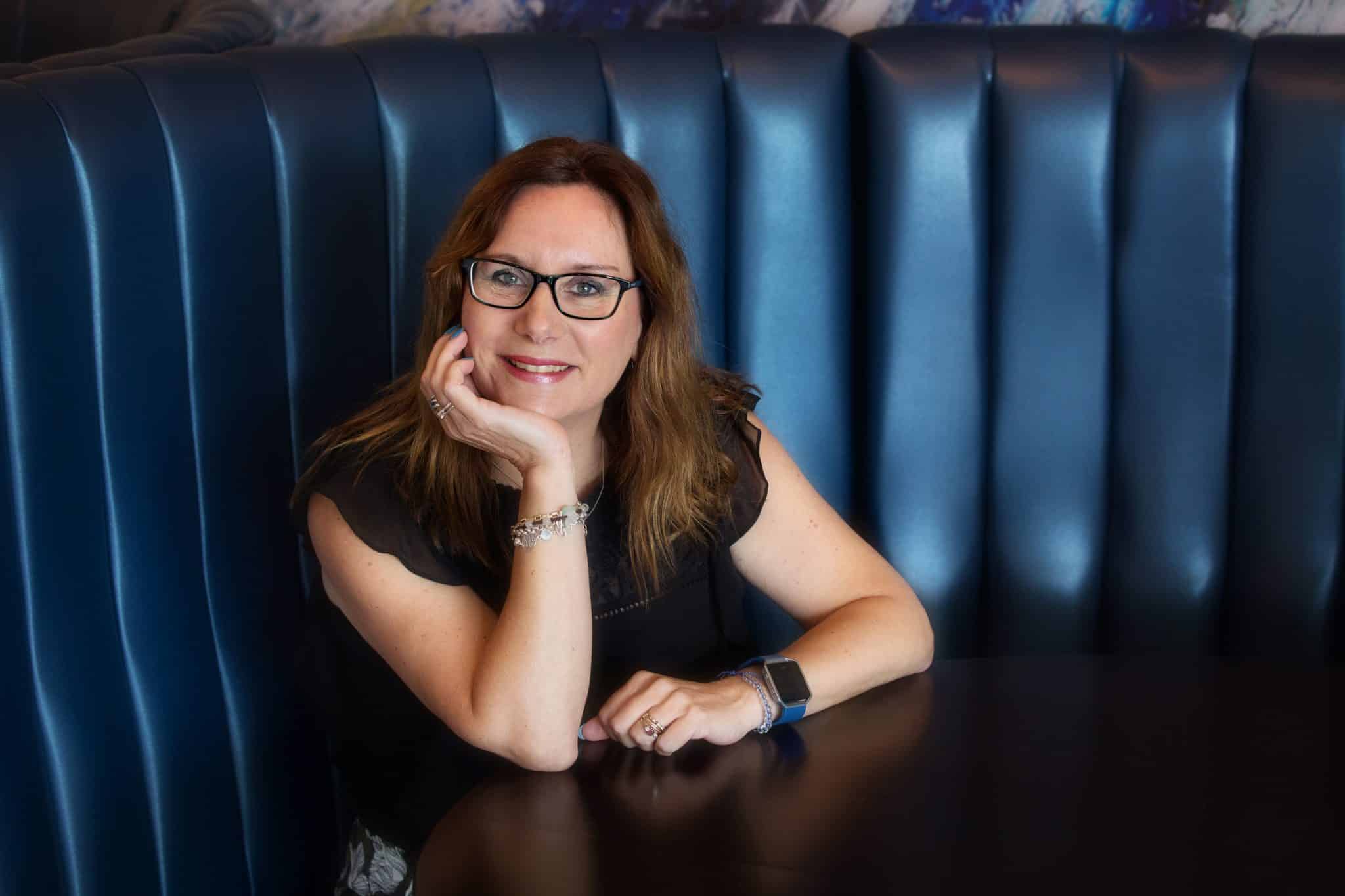 Professional woman in Suffolk business setting, smiling at the camera.