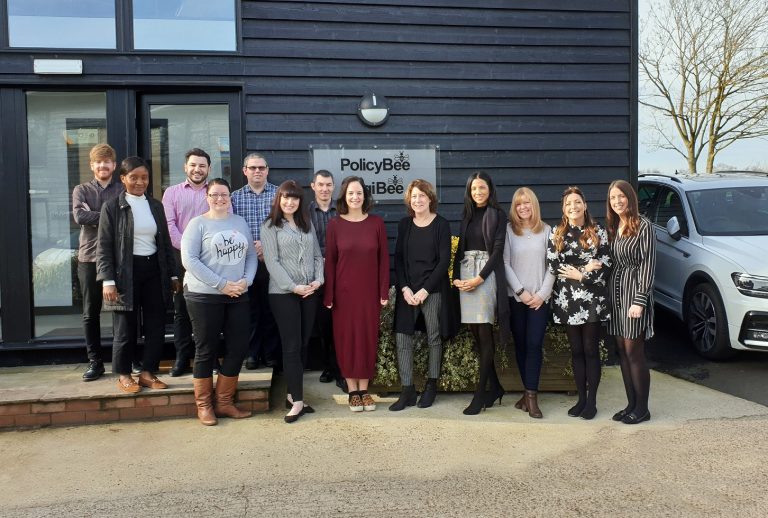 Diverse team of professionals standing outside Suffolk Business office in Suffolk, UK.