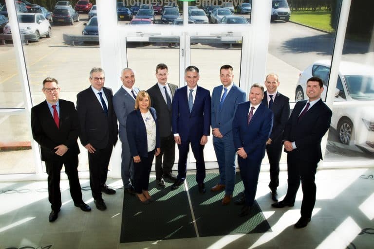 Business professionals standing together in a modern office entrance.