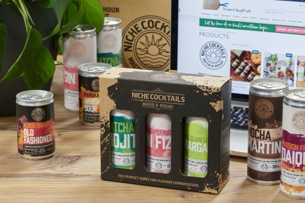 Suffolk Business cocktail gift set with flavourful mixers and cans on wooden table.