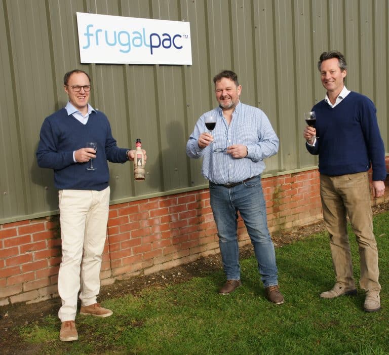 Enjoying wine at a Suffolk Business event outside a green industrial building with a "frugalpac" sig.