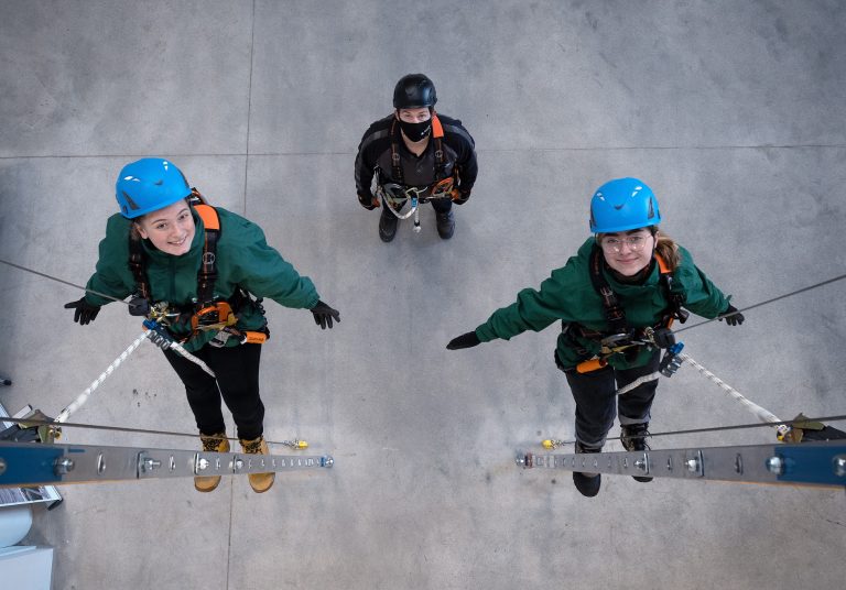 Climbers with safety gear and helmets preparing for ascent.