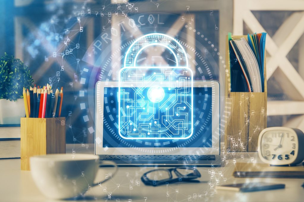 Digital security concept with a laptop displaying a lock symbol and cybersecurity graphics.