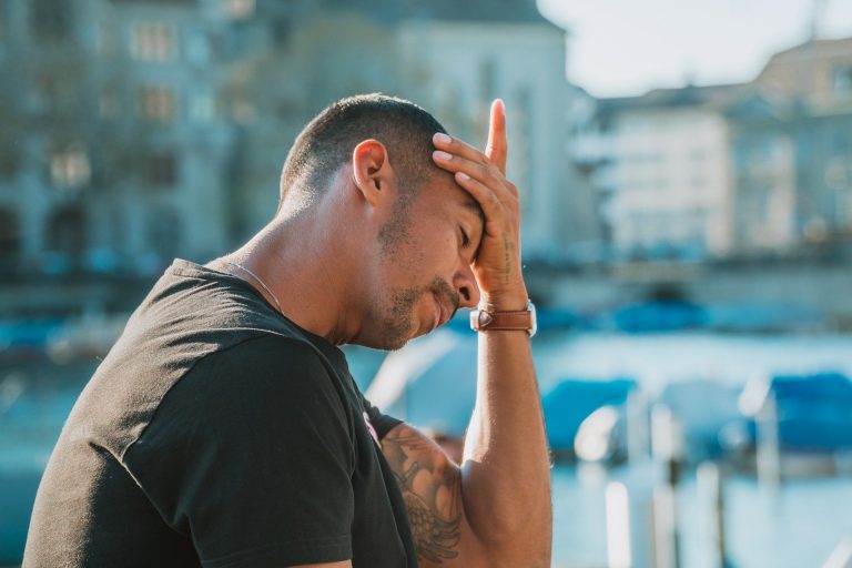 Suffolk Business - Man experiencing stress or frustration outdoors near water.