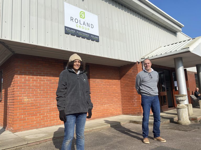 Business professionals standing outside Roland Group office in Suffolk.