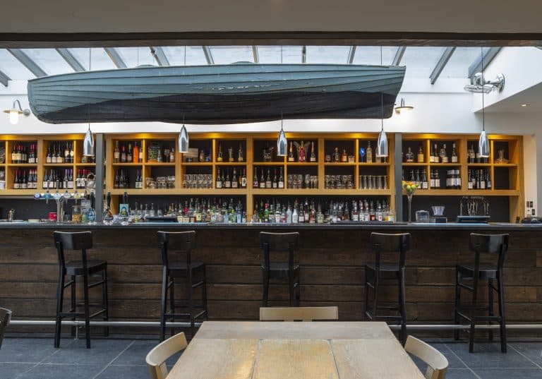 Modern bar interior in Suffolk with stylish seating and a variety of beverages.