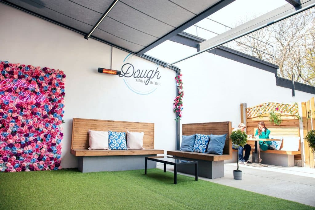 Modern outdoor lounge with seating and floral decor in Suffolk business premises.