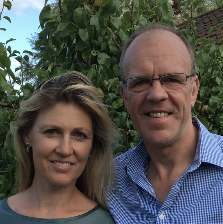 Smiling professional couple outdoors in Suffolk, representing business success and community engagem.