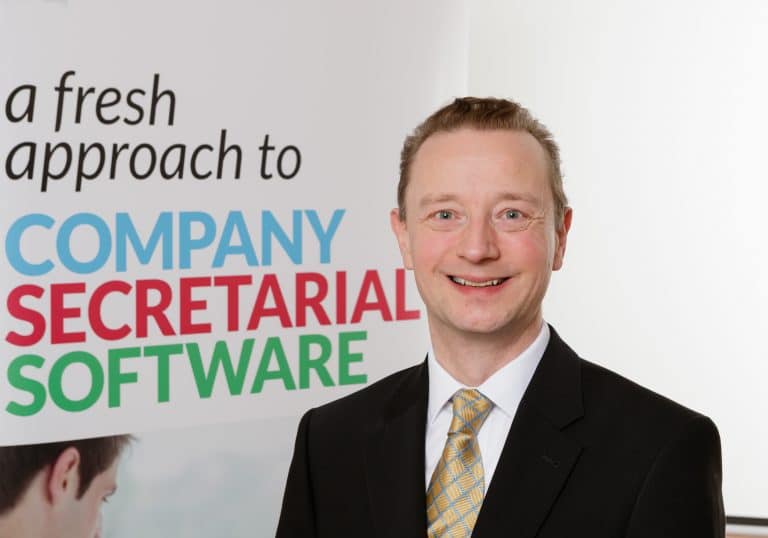 Business professional smiling with company secretarial software presentation.