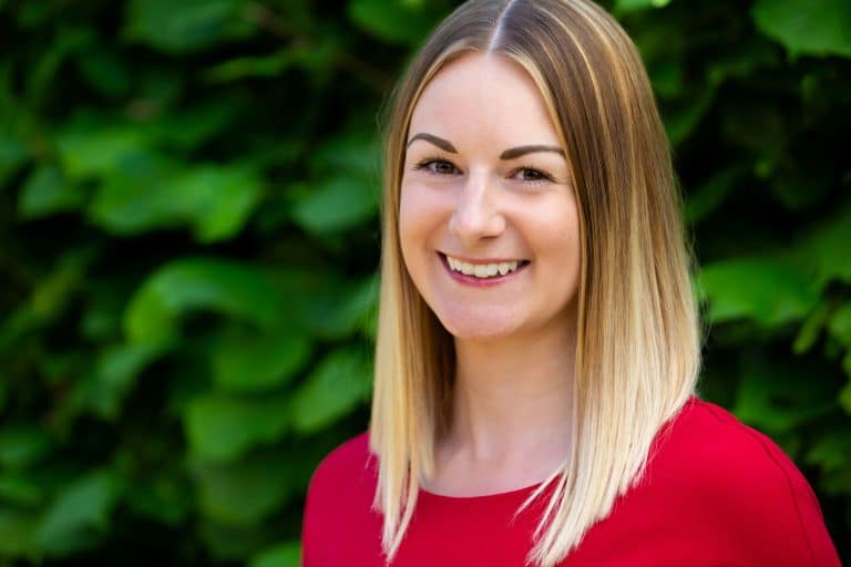 Professional woman smiling outdoors, representing Suffolk business success.