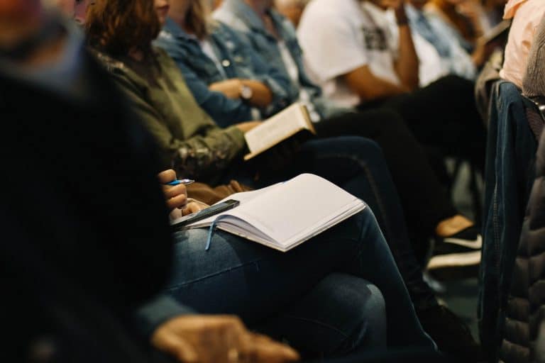 Audience attending Suffolk business conference, taking notes and listening attentively.