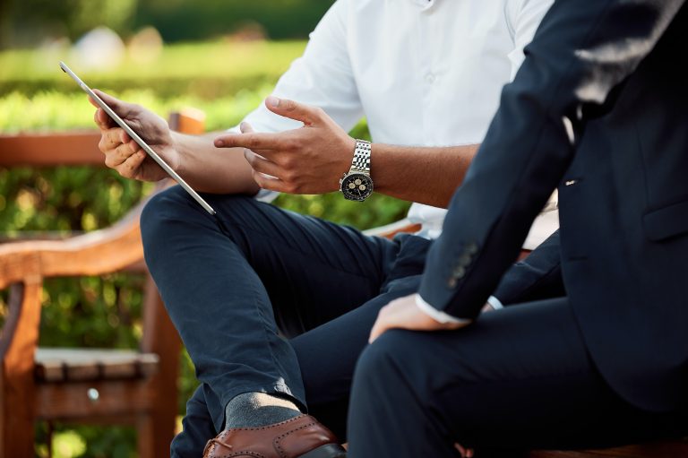 Business professionals discussing on tablet outdoors in Suffolk.