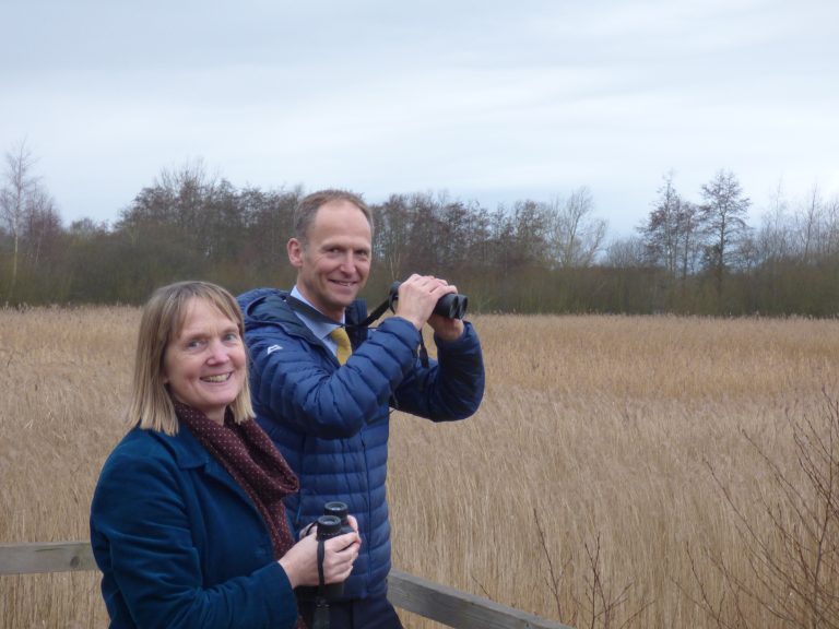 Business professionals enjoying outdoor nature observation in Suffolk countryside.