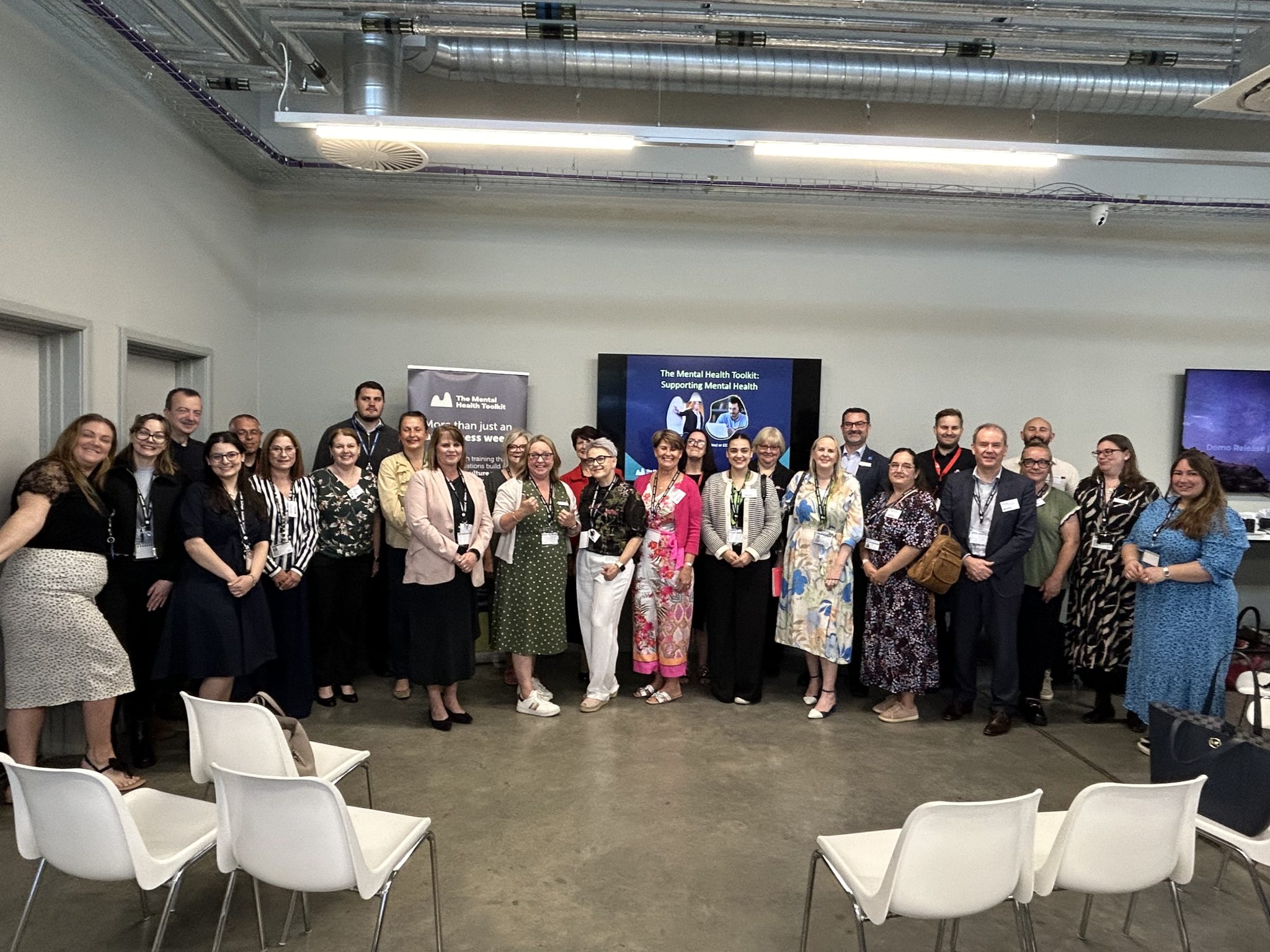 Group of diverse professionals at Suffolk Business networking event in a modern conference room.